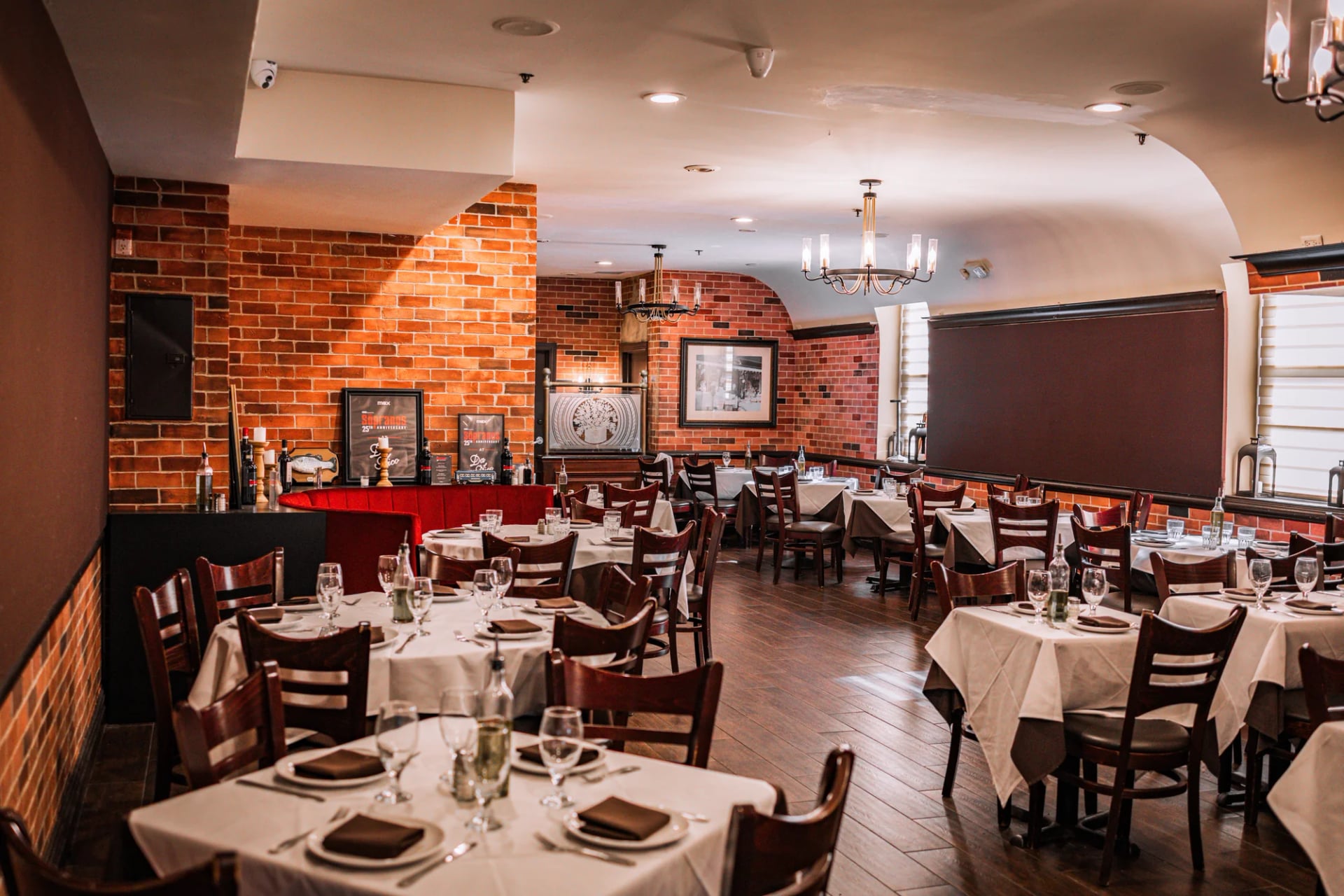 Banquette seating and a set dining table beside the exposed brick wall at Da Nico Ristorante