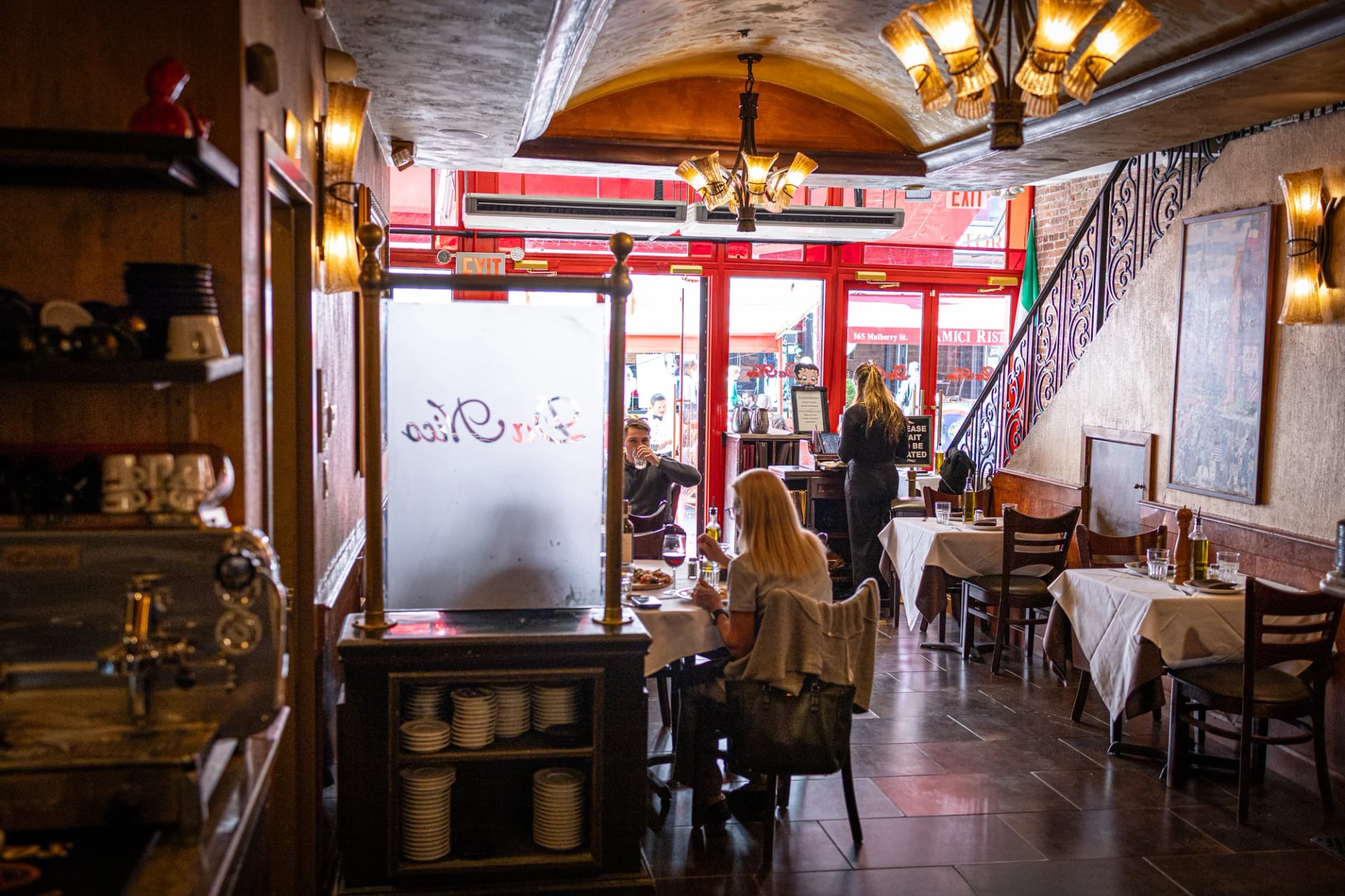 Host stand with a floral arrangement in the entrance of Da Nico Ristorante on Mulberry Street