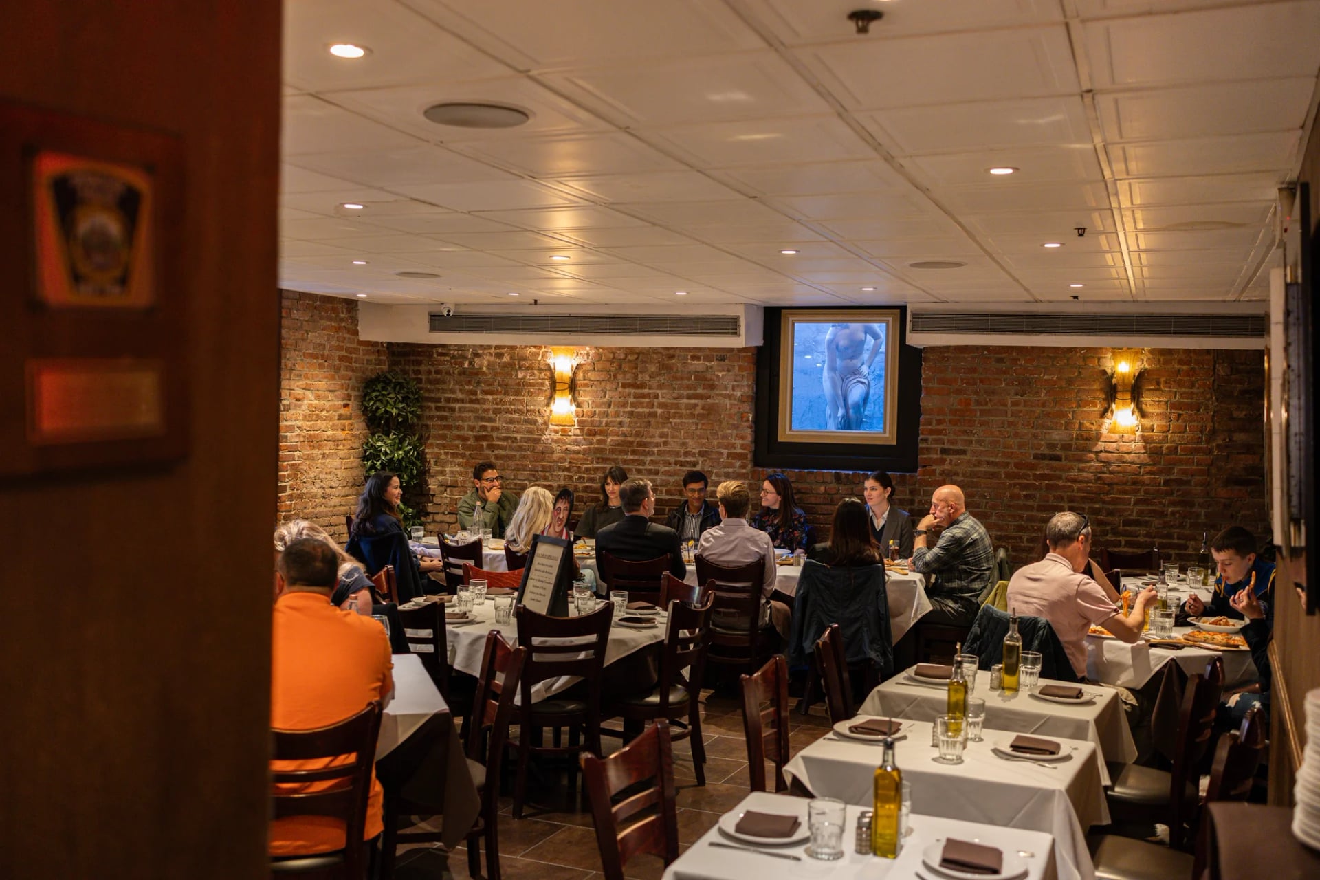 Guests seated at white-clothed tables in the Da Nico Ristorante dining room in Little Italy