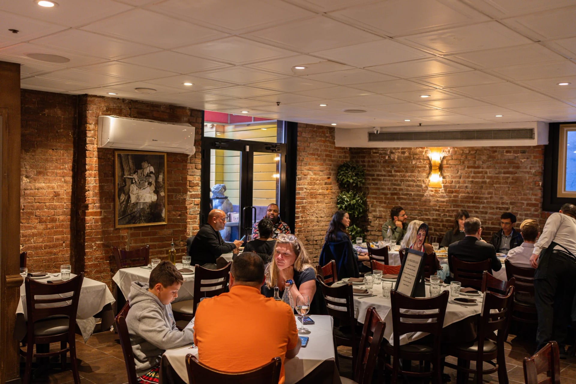 Guests dining at a round table in the Da Nico dining room on Mulberry Street