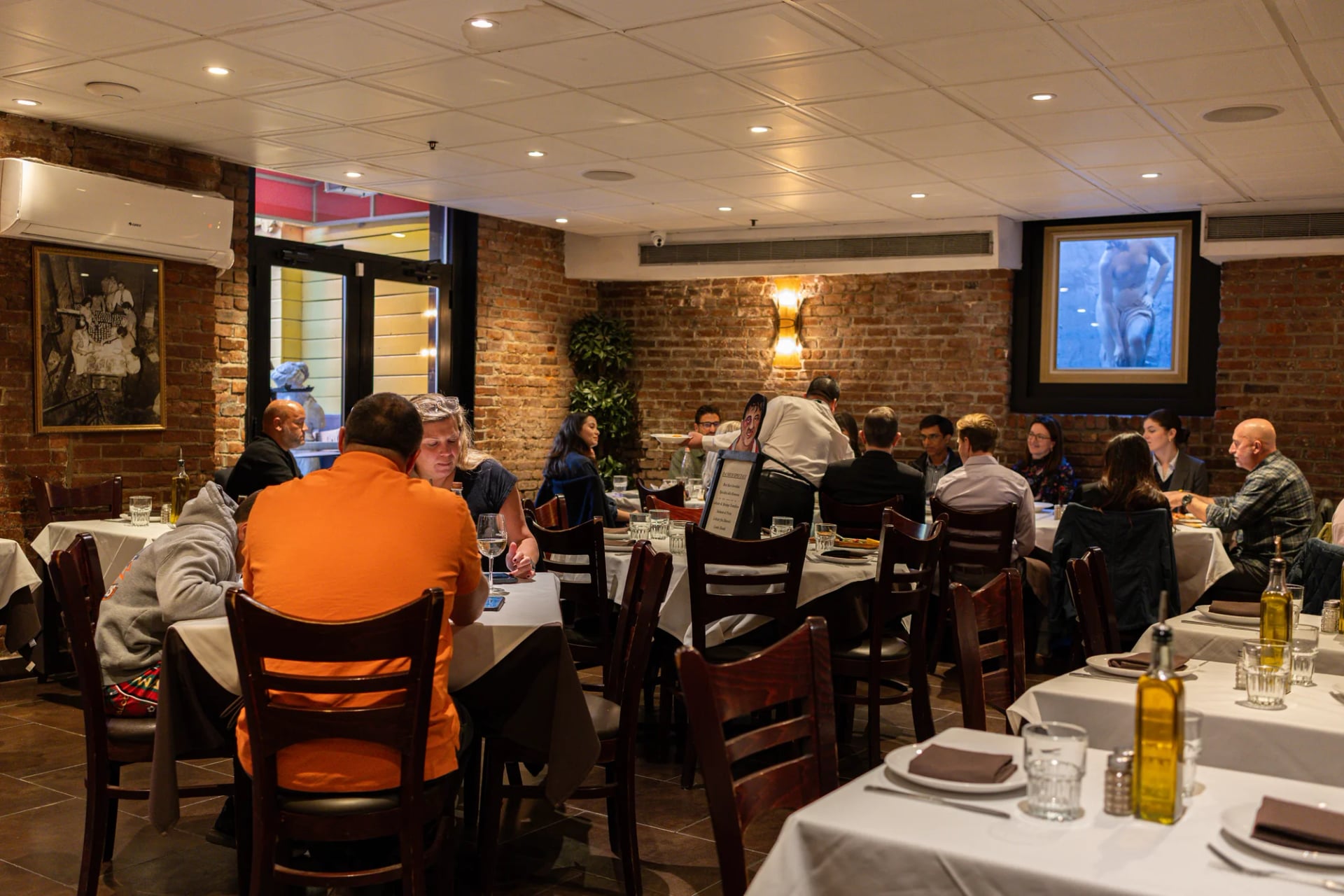 Guests at a white-clothed table in the Da Nico dining room on Mulberry Street